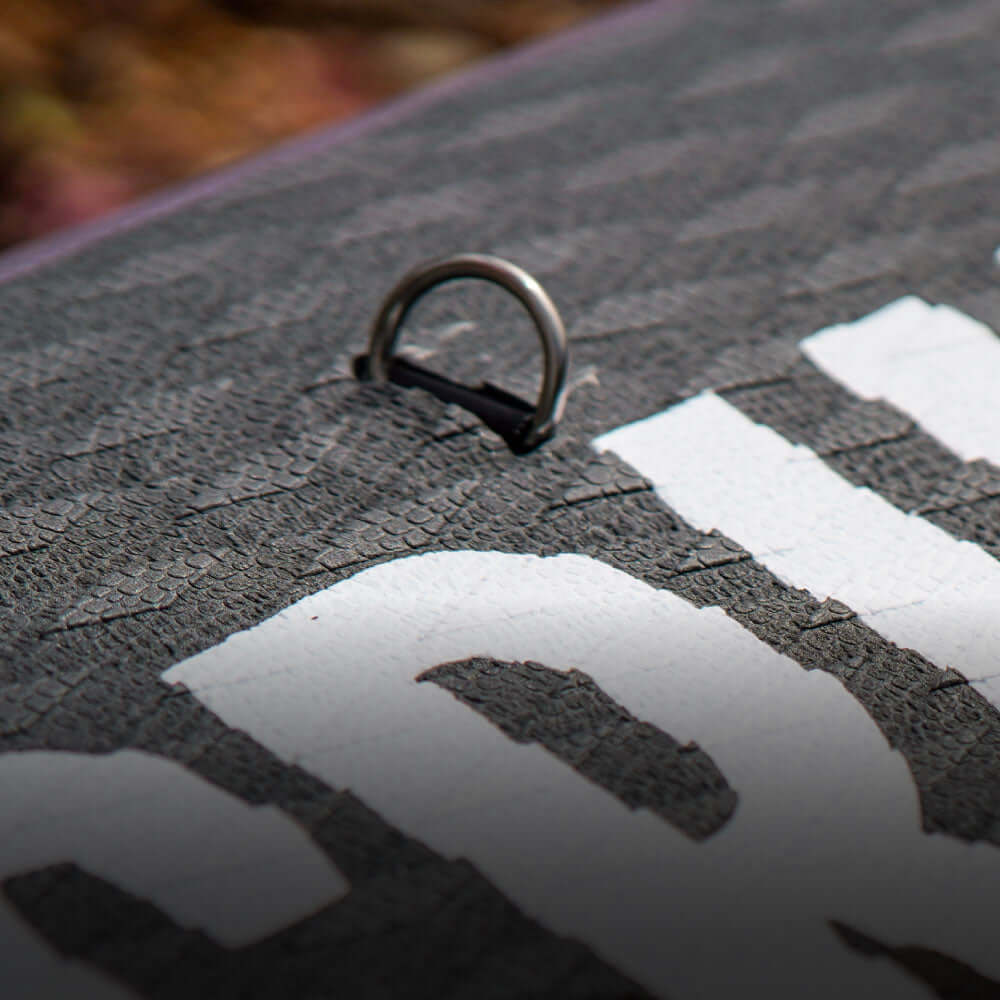 Close-up of a textured paddleboard surface with a metal D-ring attachment