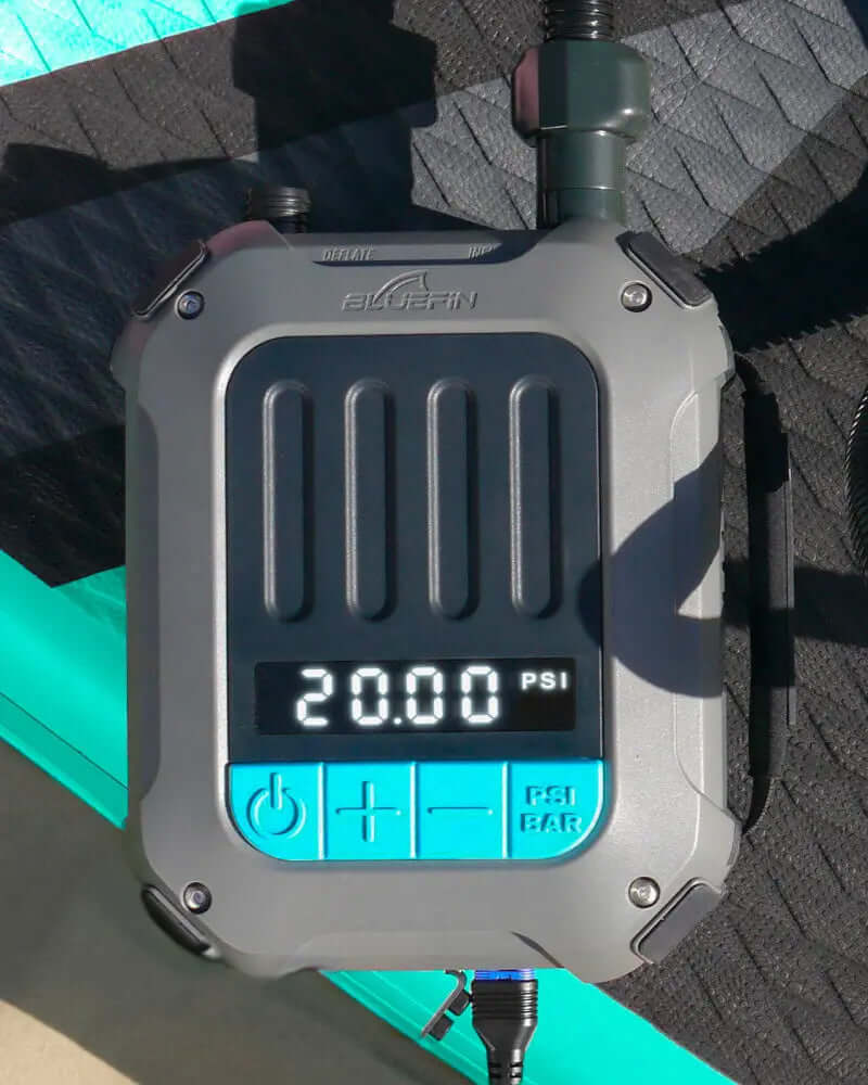 Manómetro digital mostrando 20.00 PSI, parte de un sistema de inflado Bluefin SUP sobre una superficie texturizada.