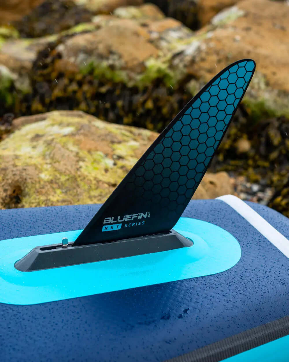 Inflatable paddleboard featuring a black hexagonal fin, blue accents, and a textured deck surface