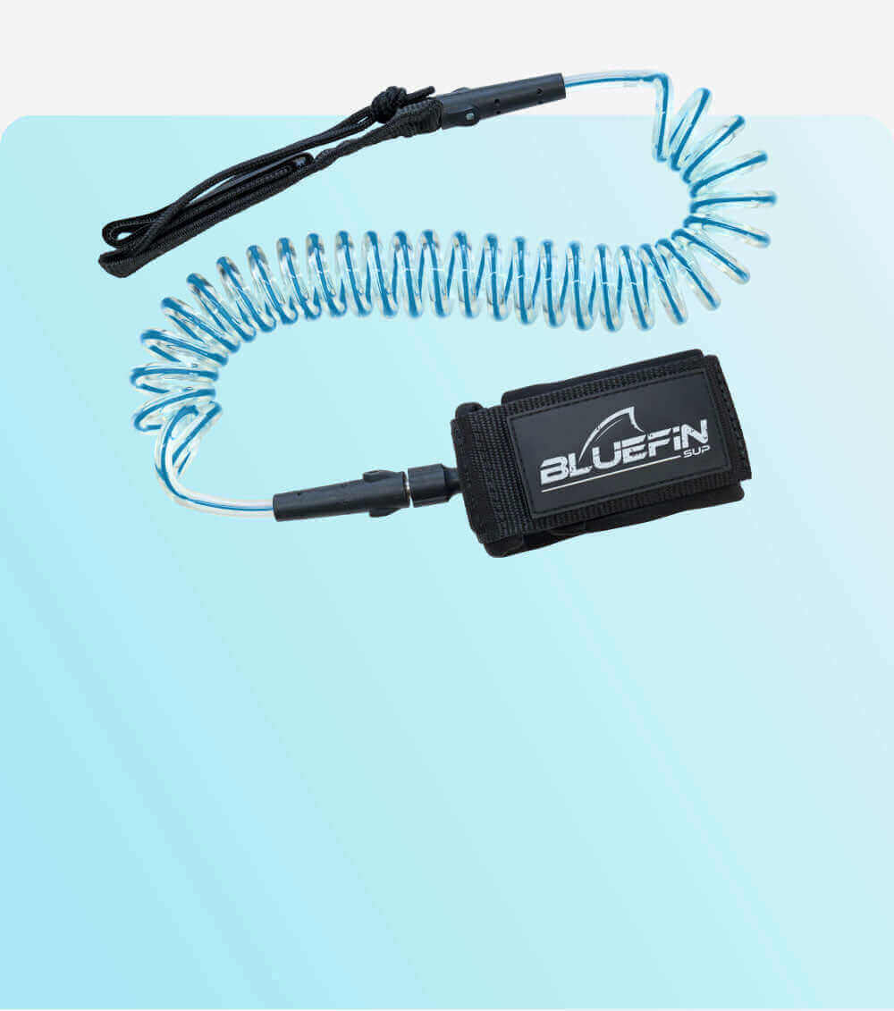 Coiled safety leash with black strap and blue cord, featuring a BLUEFIN SUP logo on the attachment.