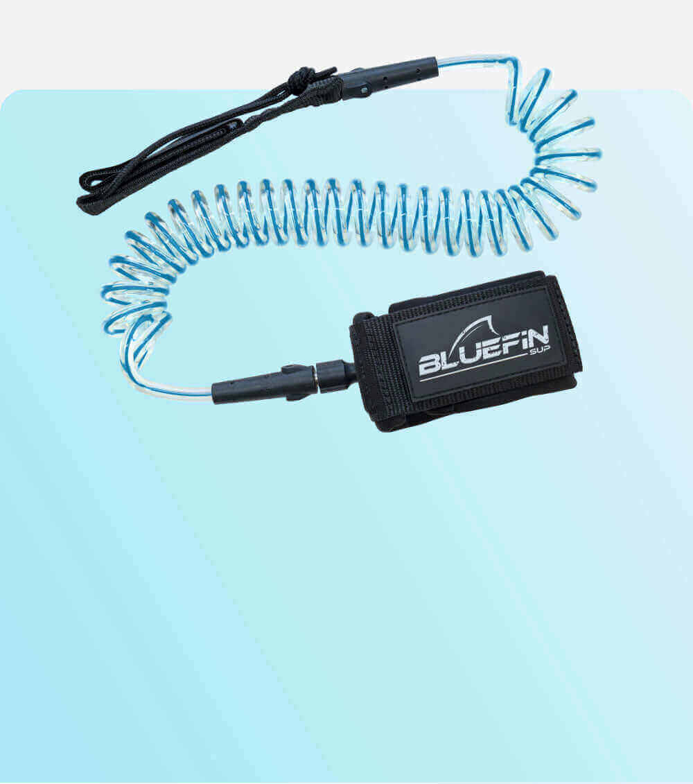 Coiled safety leash with black strap and blue cord, featuring a BLUEFIN SUP logo on the attachment.
