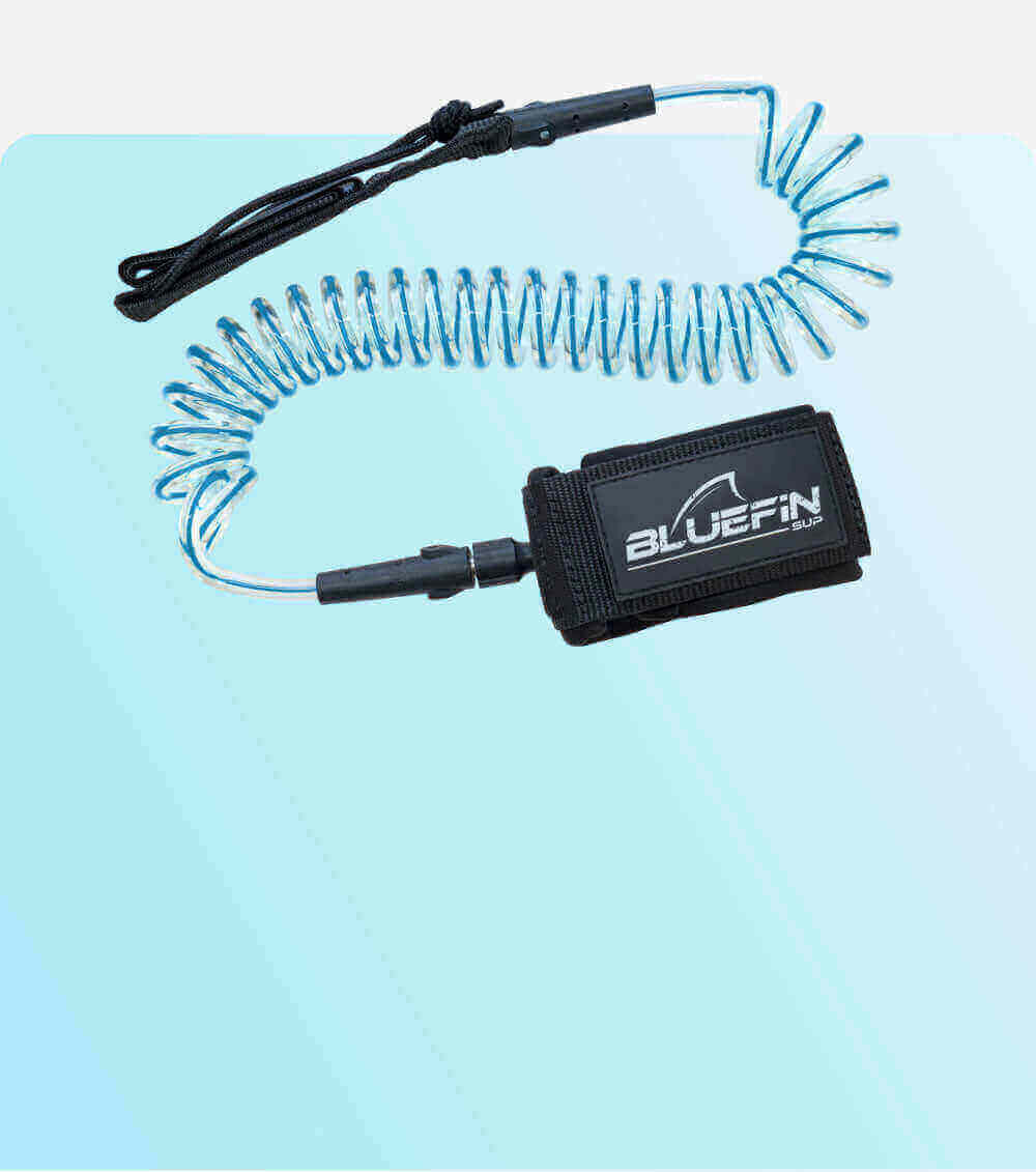 Coiled safety leash with black strap and blue cord, featuring a BLUEFIN SUP logo on the attachment.