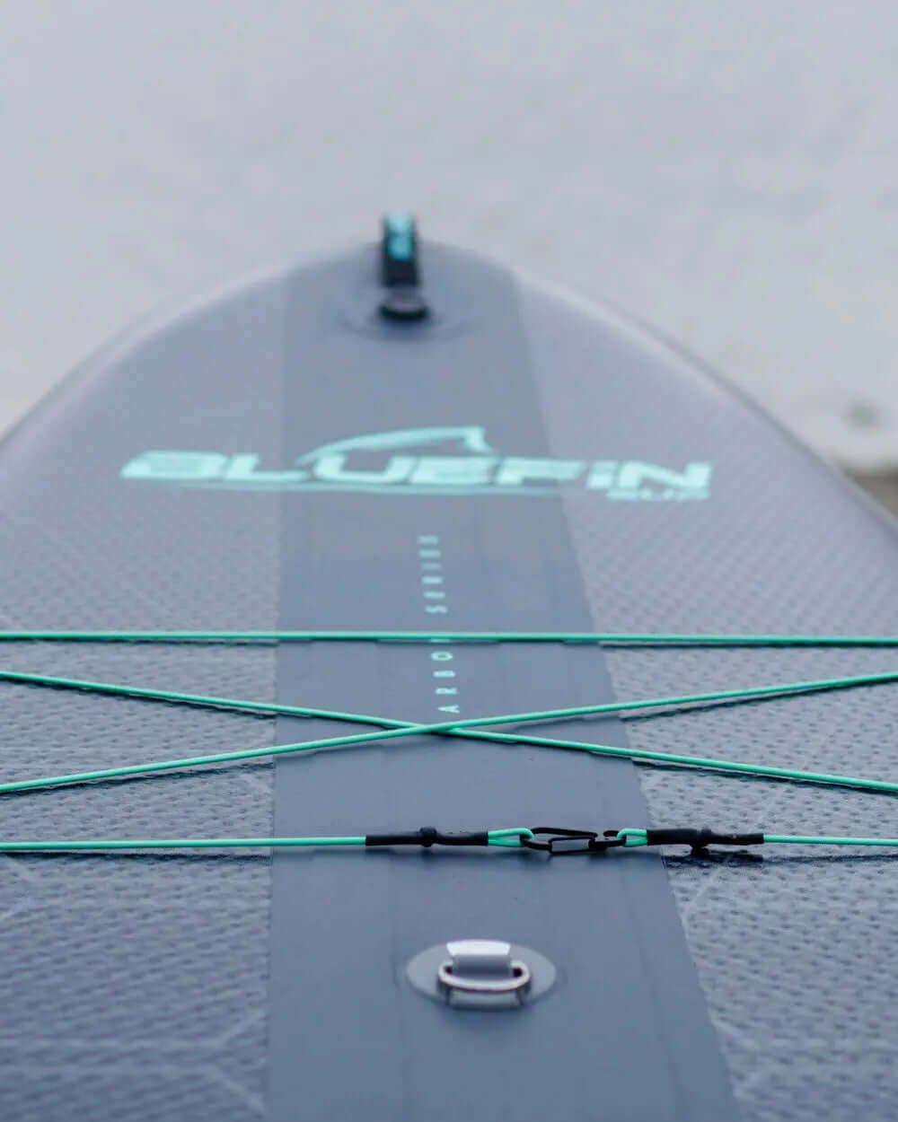 Inflatable paddleboard with textured surface, bungee cords, and inflation valve for stability