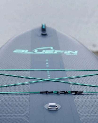 Inflatable paddleboard with textured surface, bungee cords, and inflation valve for stability