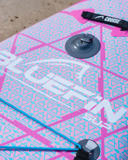 Inflatable paddleboard with pink and blue geometric design, center fin, and inflation valve